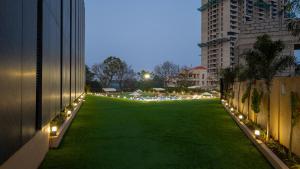 a large green field with lights on a building at Assembly By The Democracy in Nashik