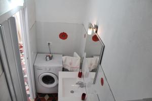 a bathroom with a washing machine and a mirror at Terrazza in Palazzo Taormina in Castellammare del Golfo +9 photos