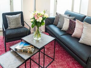 a living room with a couch and a vase of flowers on a table at Prora - Dachgeschoss Wohnung mit Sauna - Sky Lodge in Binz