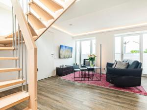 a living room with a couch and a table at Prora - Dachgeschoss Wohnung mit Sauna - Sky Lodge in Binz
