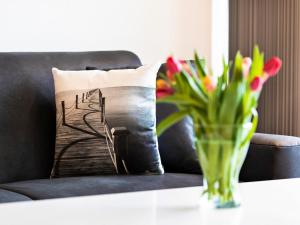 a vase of flowers on a table next to a couch at Prora - Ferienwohnung mit Balkon und Waschmaschine - Dünenheide 3,3 in Binz