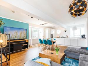 a living room with a couch and a table at Prora - Apartment mit Sauna - Baltic Sunset in Binz