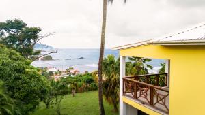 a view of the ocean from a yellow house at La Caye - Ocean View Villa in Calibishie