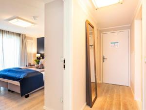 a bedroom with a bed and a mirror at Prora Block 1 - Ferienwohnung mit Pool, Sauna und Fitness - Sonnenschein in Binz