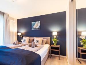 a bedroom with a large bed with blue walls at Prora Block 1 - Ferienwohnung mit Pool, Sauna und Fitness - Sonnenschein in Binz