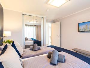 two beds in a room with a mirror at Prora Block 1 - Ferienwohnung mit Pool, Sauna und Fitness - Sonnenschein in Binz