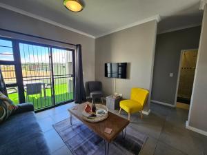 a living room with a couch and a table at Nemesia Court in Durbanville
