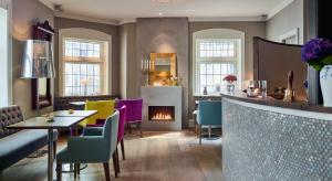 a restaurant with a fireplace and a table and chairs at Hotel Park Bergen in Bergen