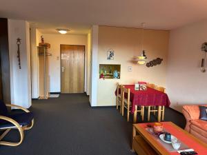 a living room with a table and a kitchen at Disentis-Mustér Ski Apartment in Disentis +13 photos