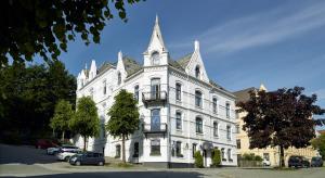 a white building with a tower on top of it at Hotel Park Bergen in Bergen