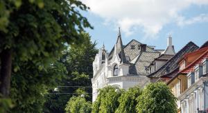 a white building with a pointed roof at Hotel Park Bergen, Historic Hotels of Europe in Bergen