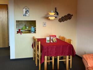 a kitchen with a table with a red table cloth at Disentis-Mustér Ski Apartment in Disentis