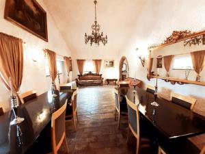 a room with a chandelier and a table and chairs at DIMORA IL CAMALEONTE country apartments with pool in Civitavecchia