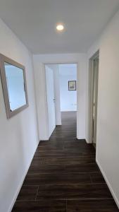 an empty hallway with white walls and wood floors at Turek Residences in Ushuaia