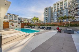 an apartment patio with a pool and chairs and a building at @ Marbella Lane - Luxury Beachside 2BR in Long Beach