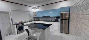 a kitchen with blue cabinets and a washer and dryer at The Natphop pool villa Meeting Pool Villa in Cha Am