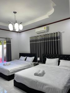 a bedroom with two beds with white sheets at The Natphop pool villa Meeting Pool Villa in Cha Am +27 photos
