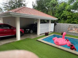 a swimming pool with a pink toy in a yard at The Natphop pool villa Meeting Pool Villa in Cha Am