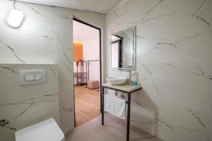 a white bathroom with a sink and a mirror at Azure Bay Resort in Sarandë +78 photos