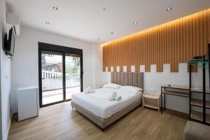 a bedroom with a white bed and a large window at Azure Bay Resort in Sarandë