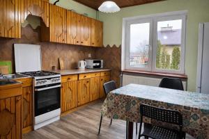 a kitchen with wooden cabinets and a table with a tableablish at Hostel Arkobaleno sieci Mazowia Hostels Group in Marki
