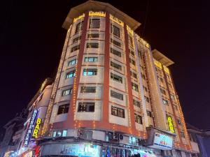 a tall building is lit up at night at Hotel Alka Residency in Thane