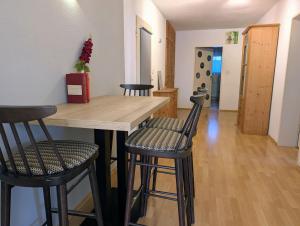 a kitchen with a wooden table and two bar stools at Apartment Kadenbach in Kadenbach +13 photos