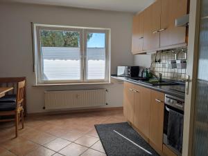 a kitchen with wooden cabinets and a large window at Apartment Kadenbach in Kadenbach