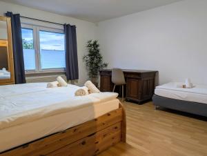 a bedroom with two beds and a desk and a window at Apartment Kadenbach in Kadenbach