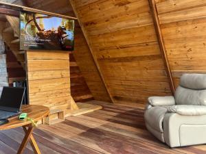 a living room with a couch and a tv at Conga Lodge Cabana Alpina in La Conga