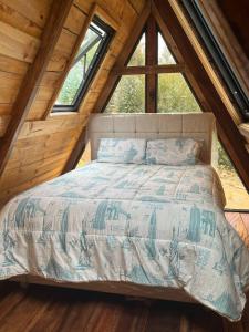 a bed in a room with a large window at Conga Lodge Cabana Alpina in La Conga