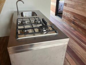 a kitchen counter with a stove and a sink at Conga Lodge Cabana Alpina in La Conga
