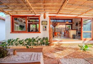 a home with a wooden roof and a patio at Morada Pochixá in Corumbau