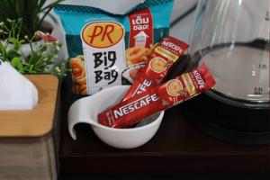 een tafel met een kom met eten en een bakje melk bij Rungarun Residence in Ratchaburi +5 foto's