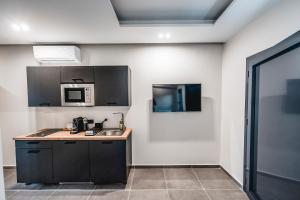 a kitchen with a sink and a microwave at Nima Suites Corfu in Marathias