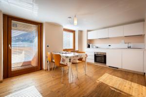 a kitchen with a table and chairs in a room at La Marmote Albergo Diffuso di Paluzza Aip in Paluzza