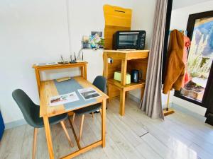 a room with a desk and a table with a computer at Studio aux Sources de la Chabanne in Saint-Hilaire-les-Courbes