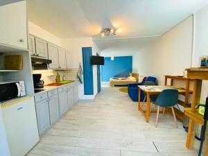 a kitchen and living room with a table and chairs at Studio aux Sources de la Chabanne in Saint-Hilaire-les-Courbes