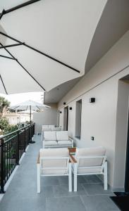 a row of white chairs and umbrellas on a balcony at Nima Suites Corfu in Marathias