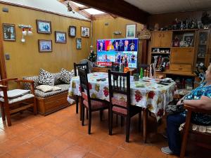 a dining room with a table and chairs and a tv at Hospedaje Lala in Villarrica