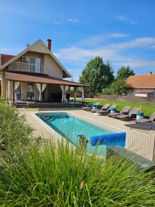 a swimming pool in front of a house at Tiszavirág Üdülőház in Kisköre