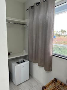 a bathroom with a shower curtain and a window at Pousada Guanumbi in Morretes