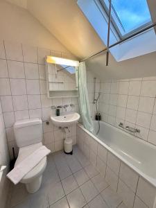 een badkamer met toilet, wastafel en ligbad bij Living Cozy in Bern in Bern