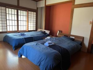 three beds in a room with blue sheets on them at Samurai Hotel Naraiso in Narai +45 photos
