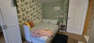 a small bedroom with a small bed in it at La Maison Ôtrement in Martelange +28 photos
