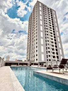a large building with a swimming pool in front of it at Apartamento completo e elegante no centro de Pouso Alegre in Pouso Alegre