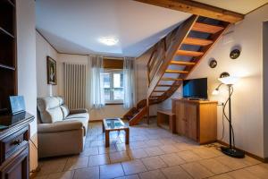 a living room with a couch and a staircase at Treppo Centro in Treppo Carnico