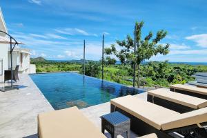 a swimming pool with a view of the ocean at Passot Hills - Villas Premium in Nosy Be