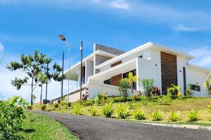 a white house with a road in front of it at Passot Hills - Villas Premium in Nosy Be