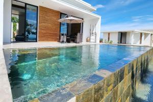 a swimming pool in front of a house at Passot Hills - Villas Premium in Nosy Be